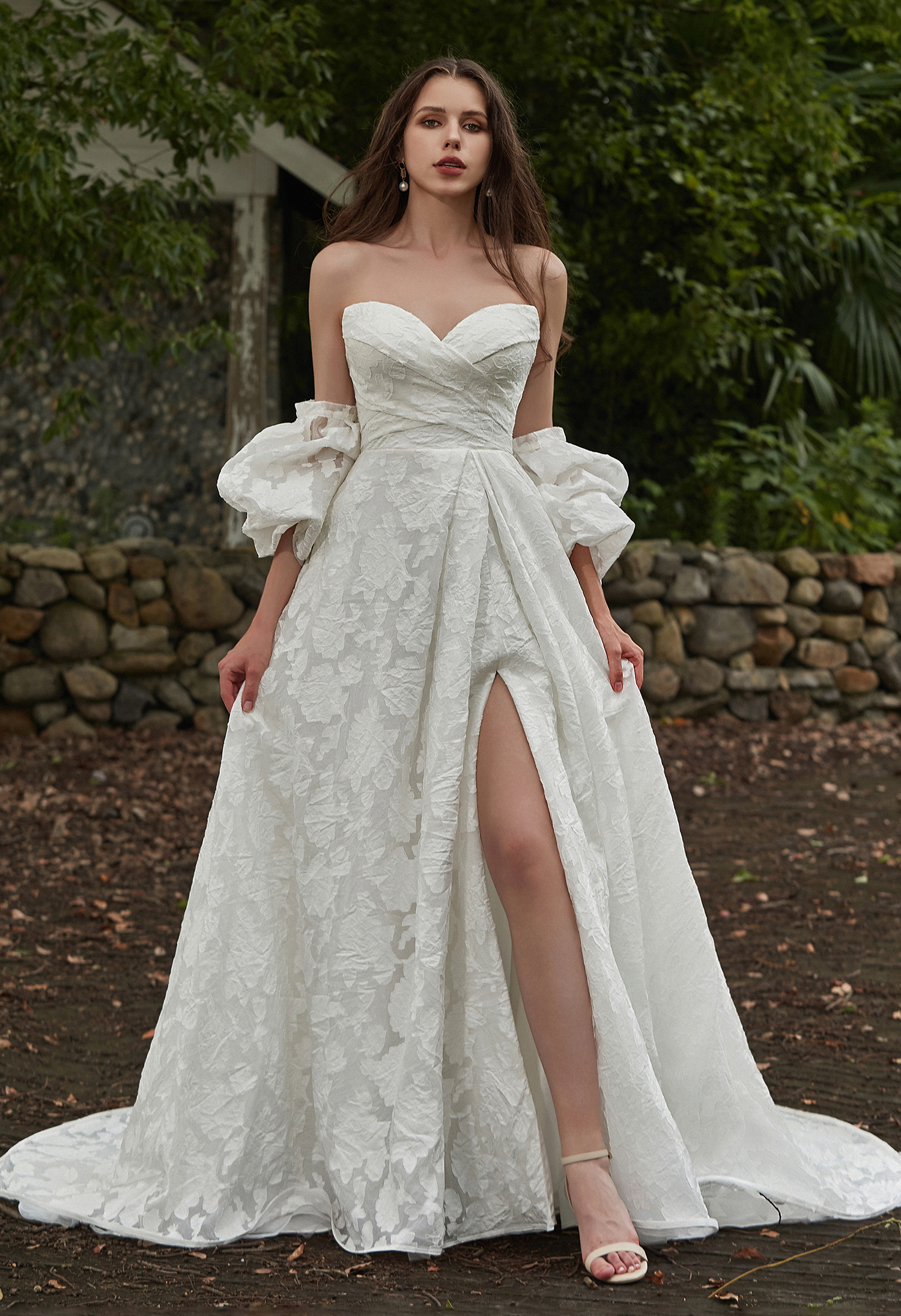 A dreamy off-the-shoulder gown with 3D floral texture and airy sleeves. Perfect for brides who love romance and whimsy, 