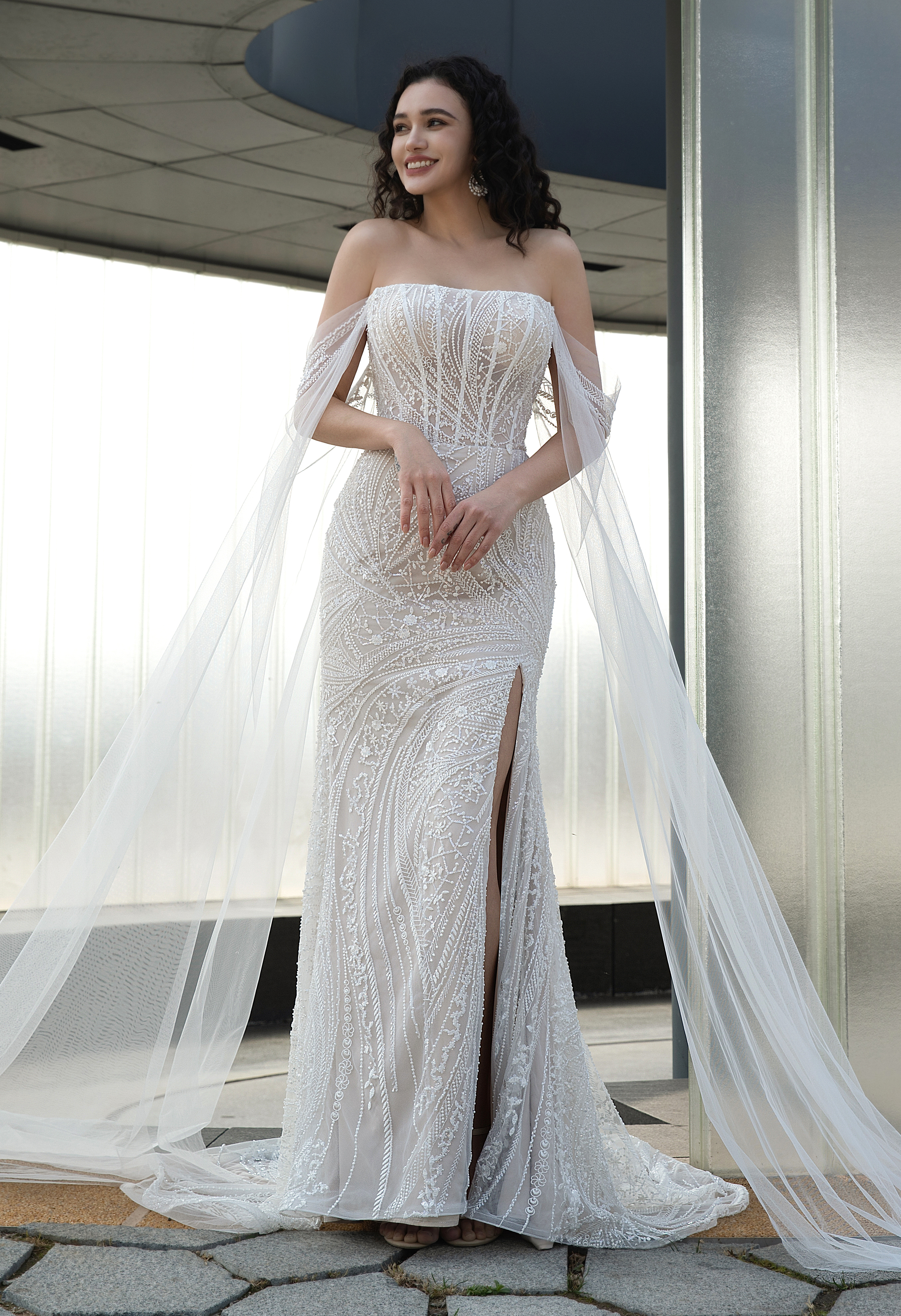 Sparkling beadwork and flowing tulle drapes create pure glamour. Ideal for modern brides wanting shine with sophisticati