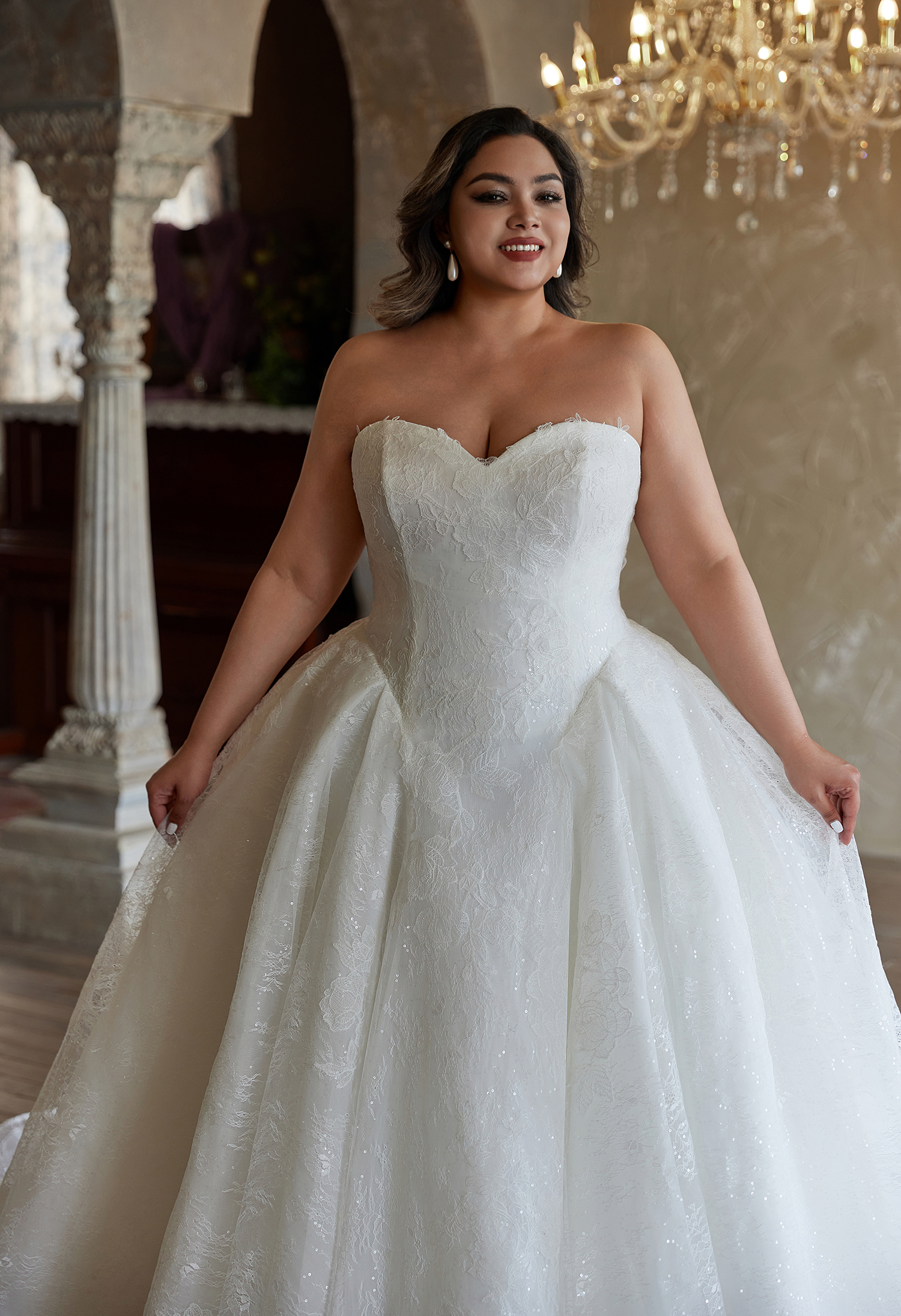 This strapless lace ball gown shimmers with subtle sparkle and a sweetheart neckline. Perfect for brides seeking timeles