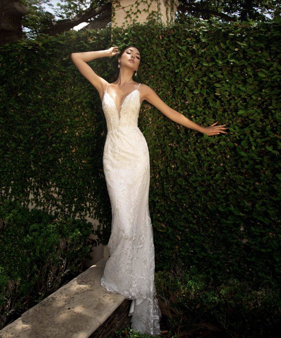 A breathtaking lace wedding gown featuring a deep illusion back, delicate spaghetti straps, and a fitted silhouette that