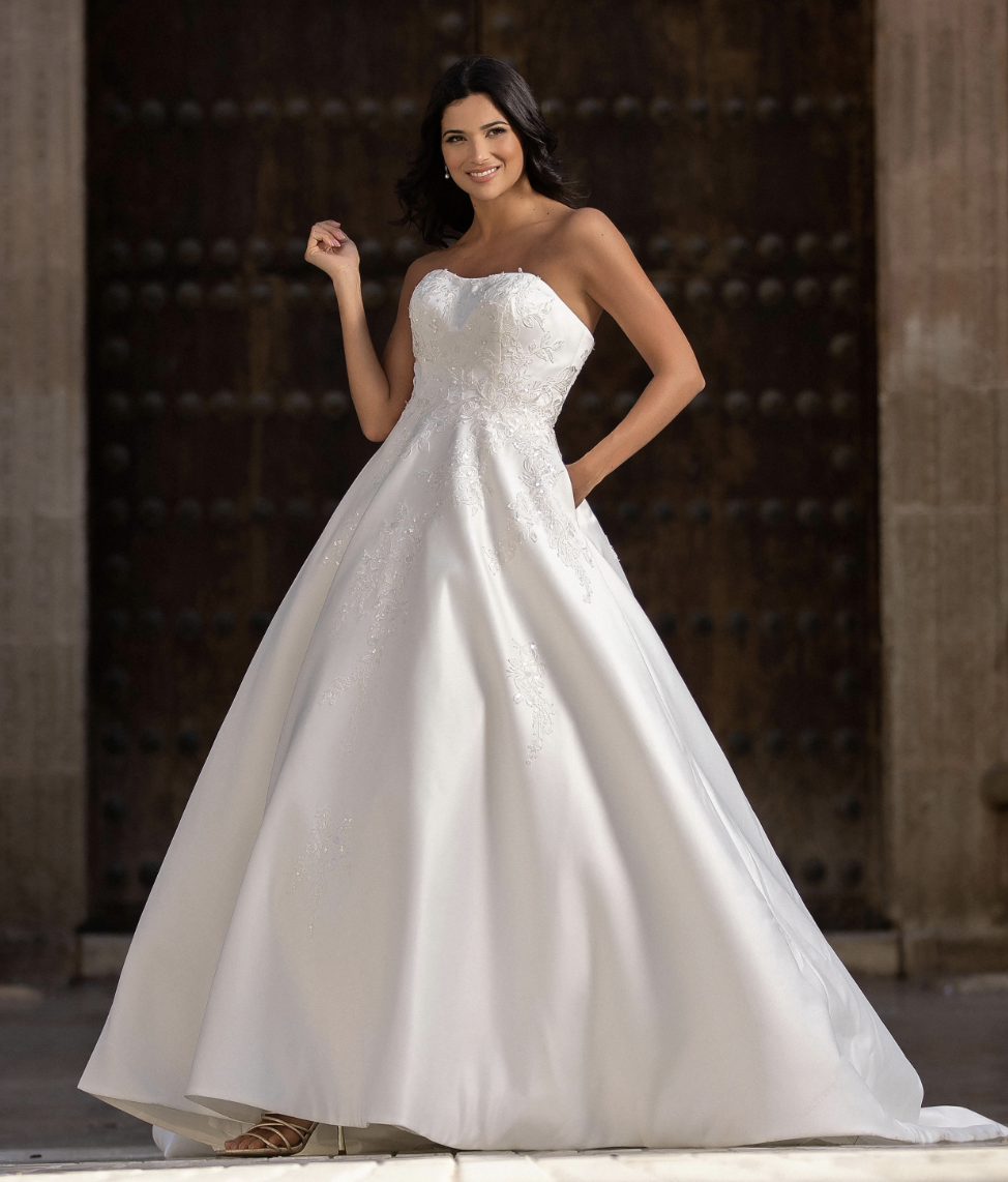 A modern take on timeless bridal style — this satin ballgown features a romantic strapless neckline, delicate beaded emb