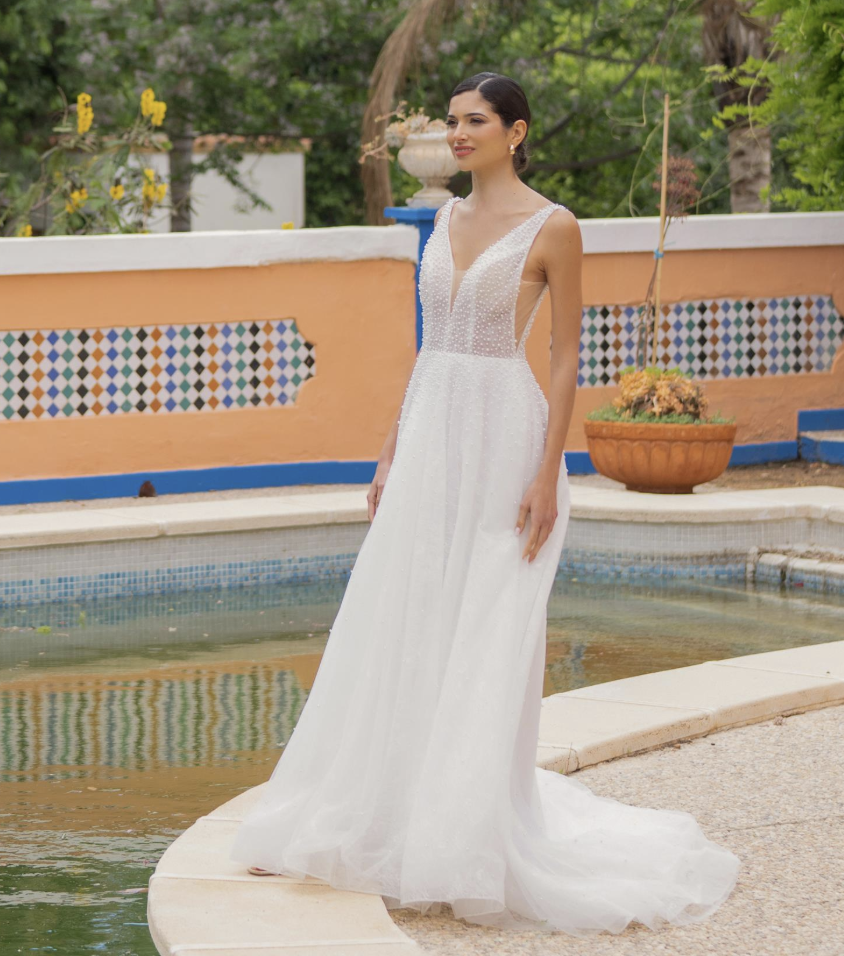 Light, romantic, and endlessly chic — this beaded tulle A-line wedding gown features a deep V-neckline, side illusion pa