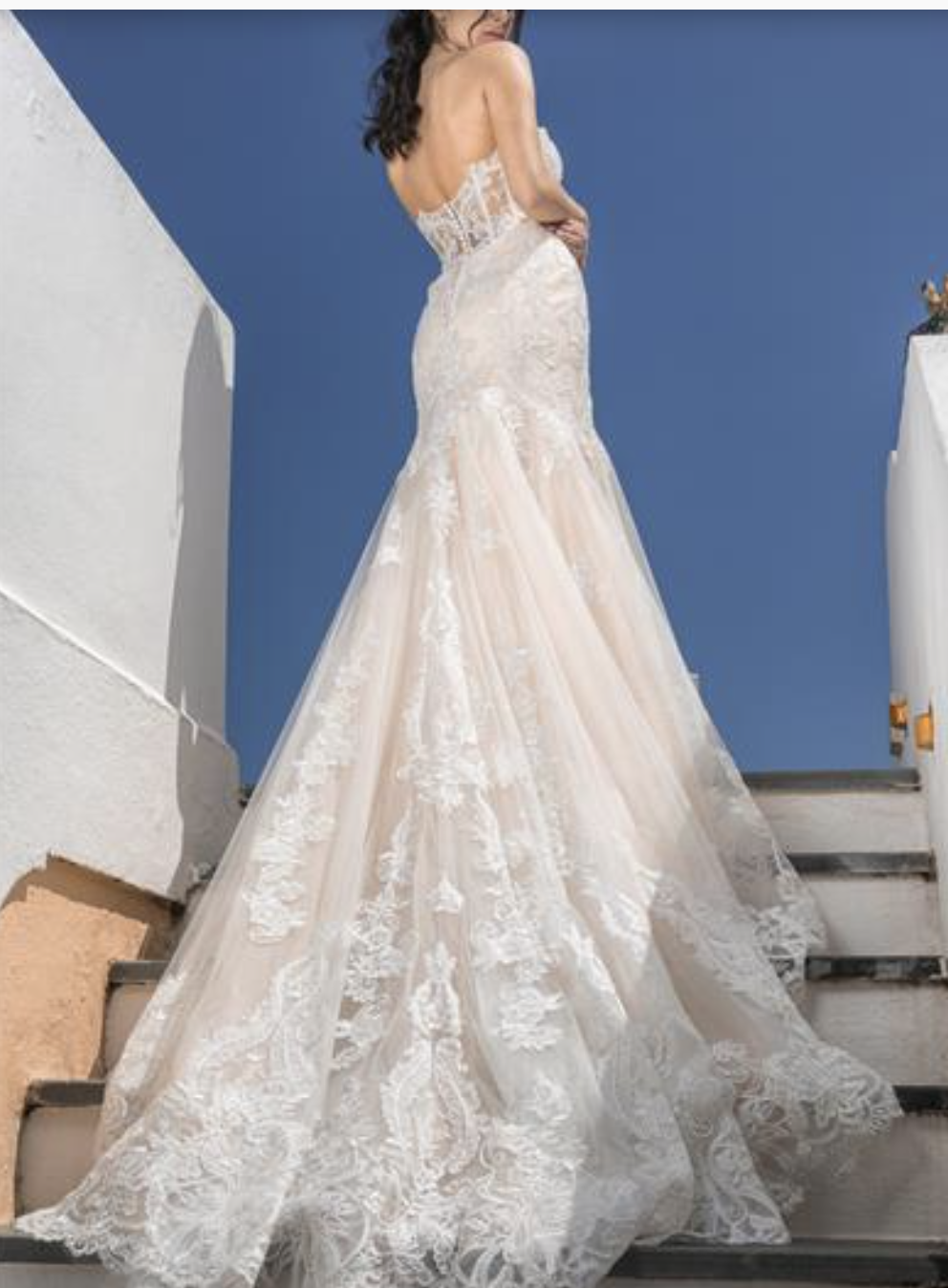 A breathtaking lace mermaid gown with a sheer corset back and dramatic chapel-length train that exudes confidence and el