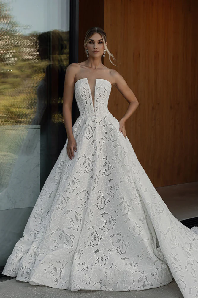 A modern take on classic romance. This strapless ball gown features bold floral lace, a sculpted bodice, and a dramatic 