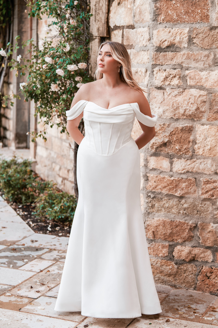 A timeless satin gown featuring a structured corset bodice and off-shoulder neckline. The elegant draping and smooth fit