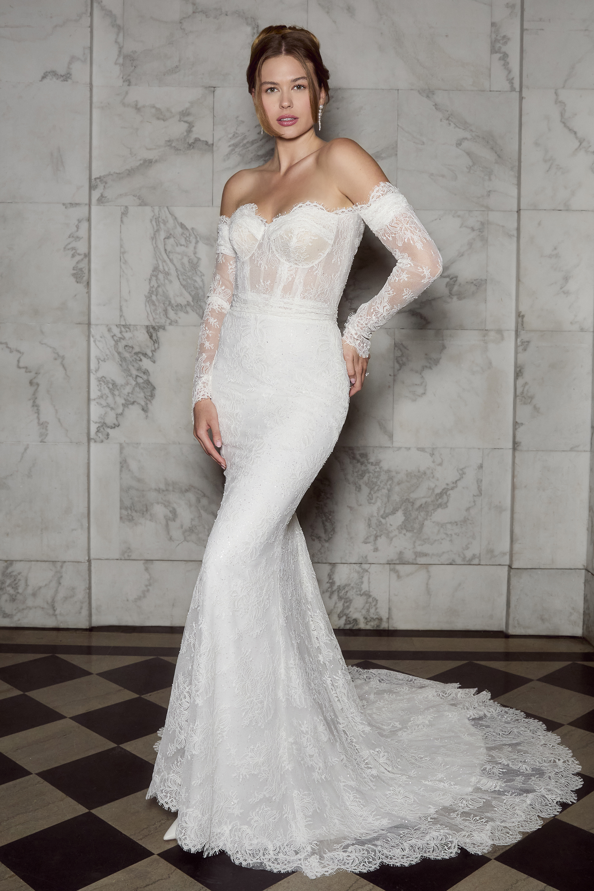 shoulder neckline, sheer corset bodice, and figure-hugging silhouette that exudes timeless romance. The delicate long sl