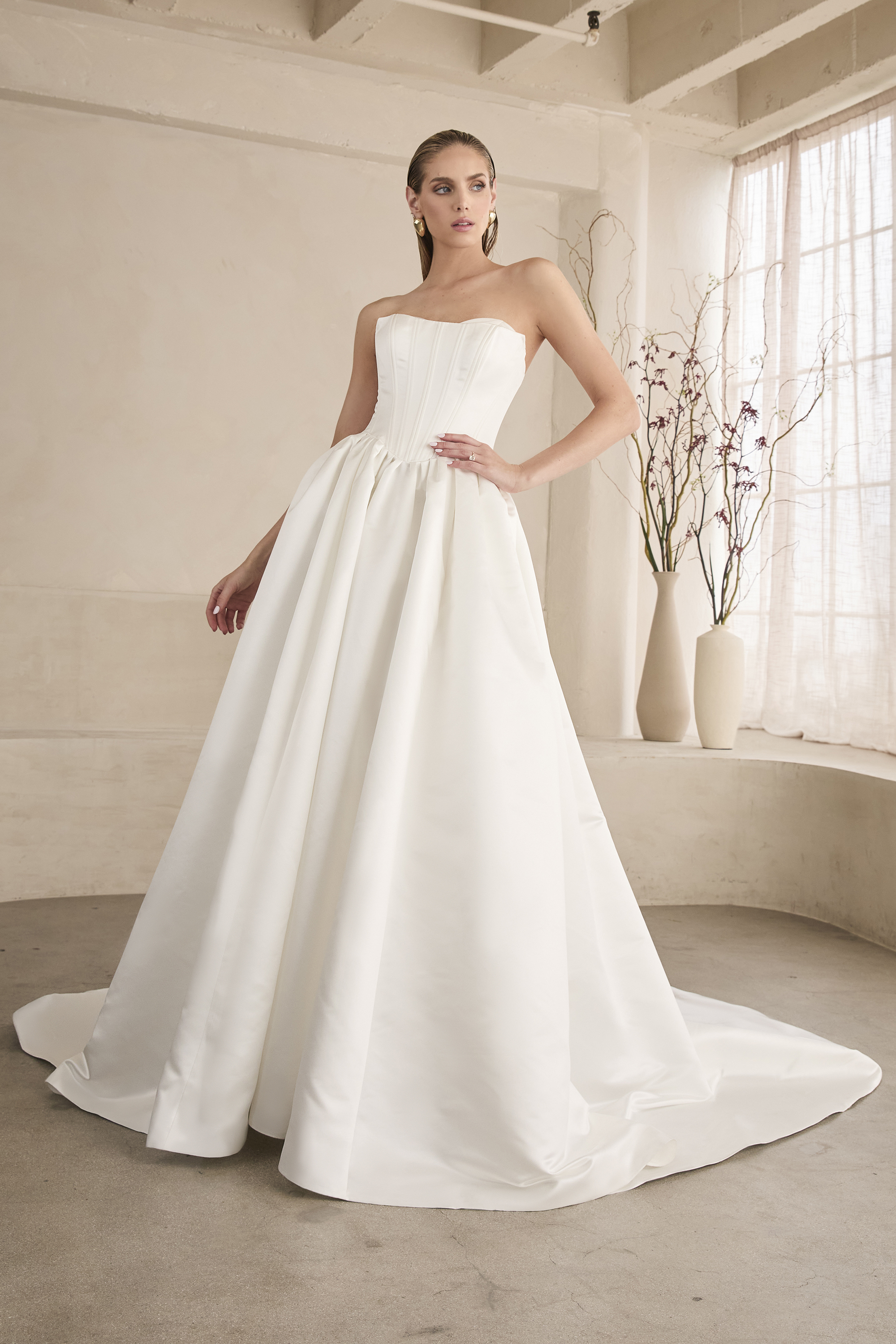 Modern meets timeless in this strapless satin ball gown featuring a structured corset bodice and full skirt that flows w