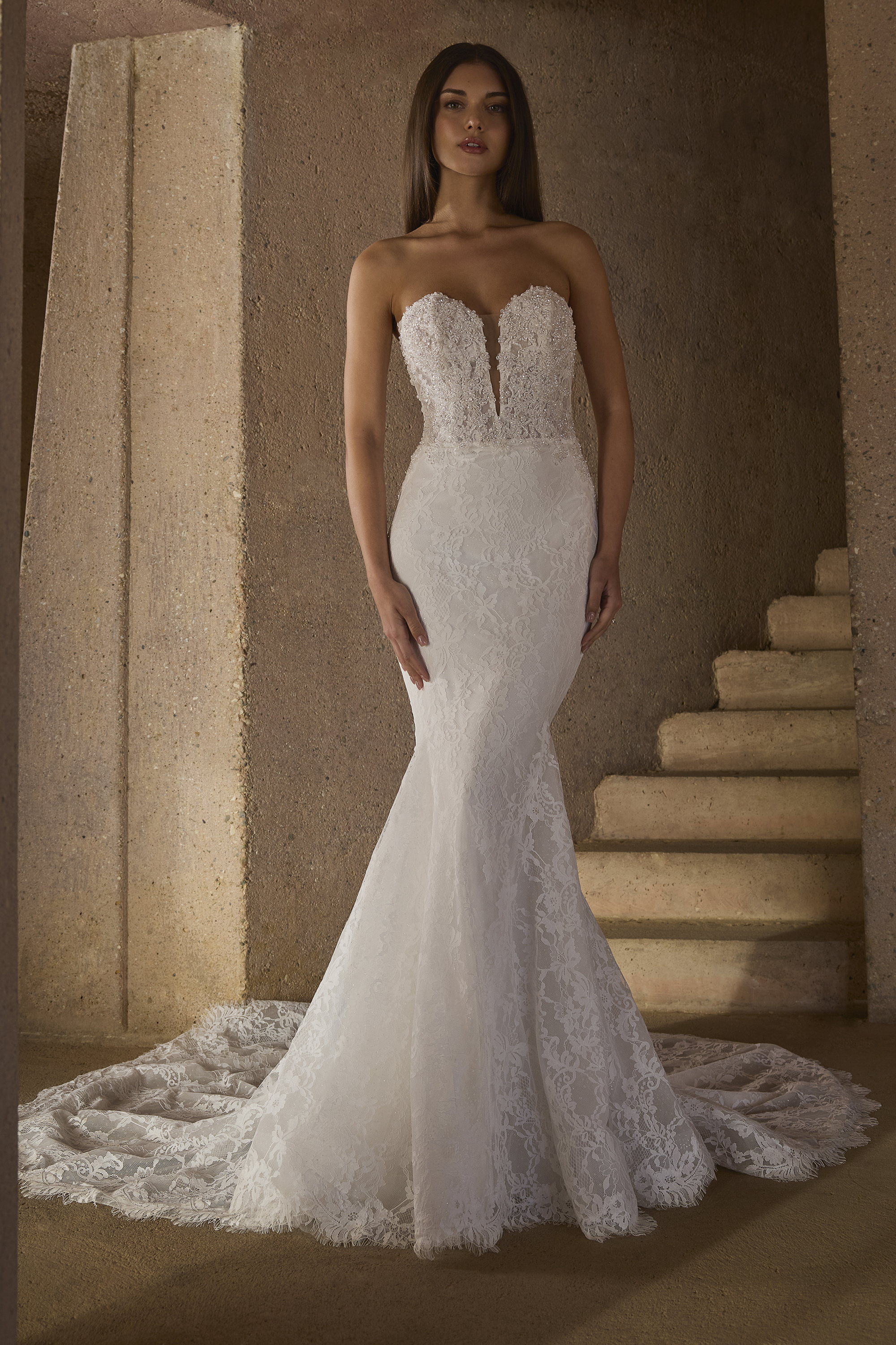 This strapless lace mermaid gown blends romance and allure with a deep sweetheart neckline and sculpted silhouette that 