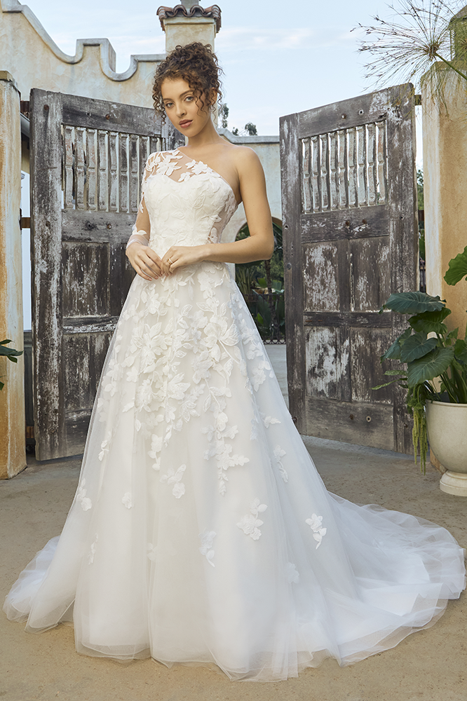 Ethereal and romantic, this one-shoulder A-line wedding dress features 3D floral lace appliqués that bloom across soft l
