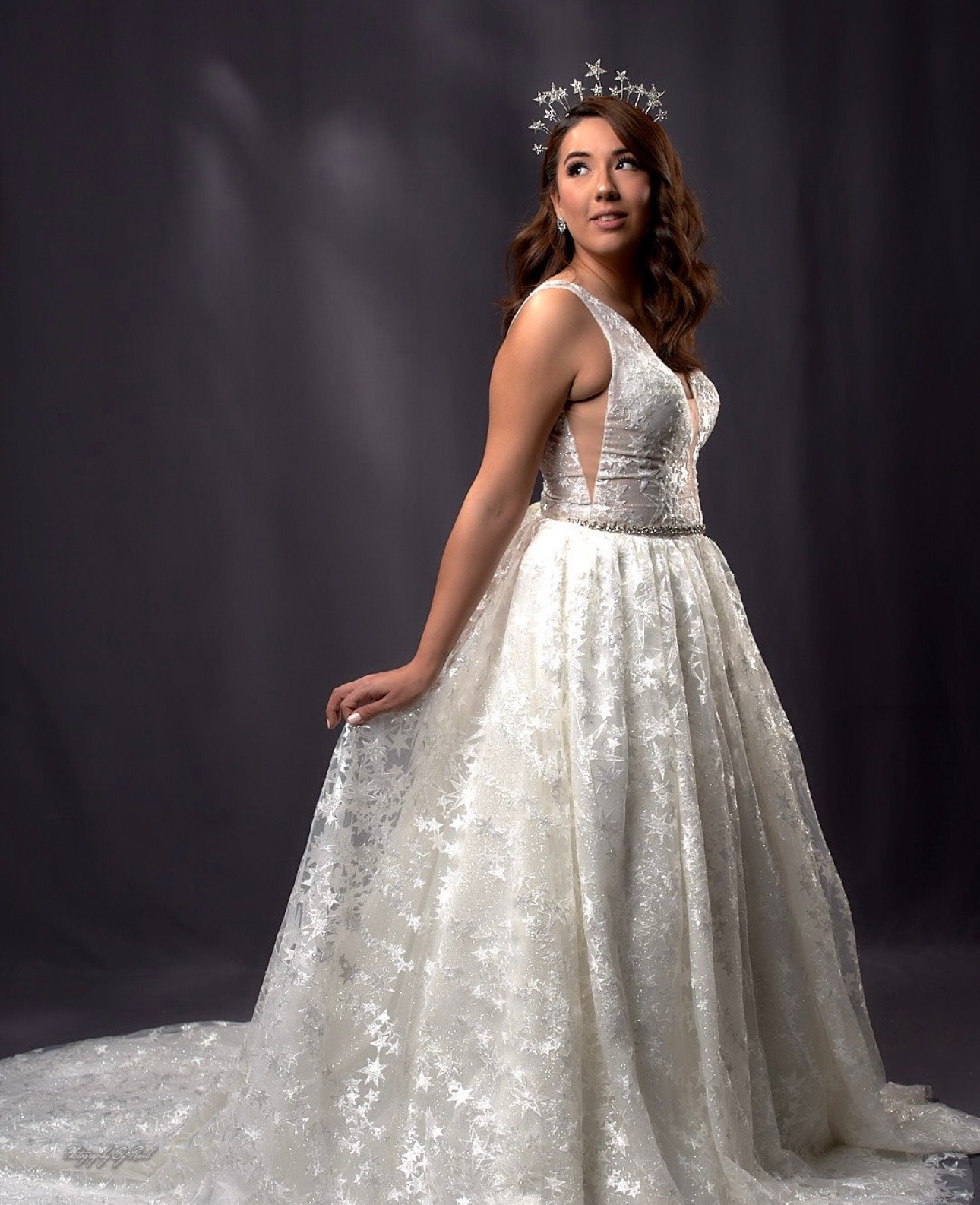 Shine like the night sky in this celestial-inspired ball gown adorned with shimmering lace and delicate star motifs. The