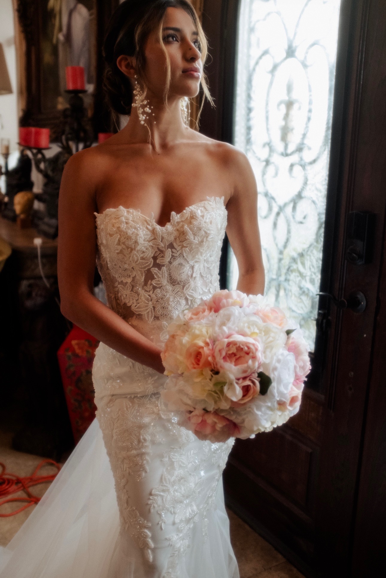 This romantic strapless gown features a sheer lace bodice with intricate floral appliqués that flow seamlessly into a cu