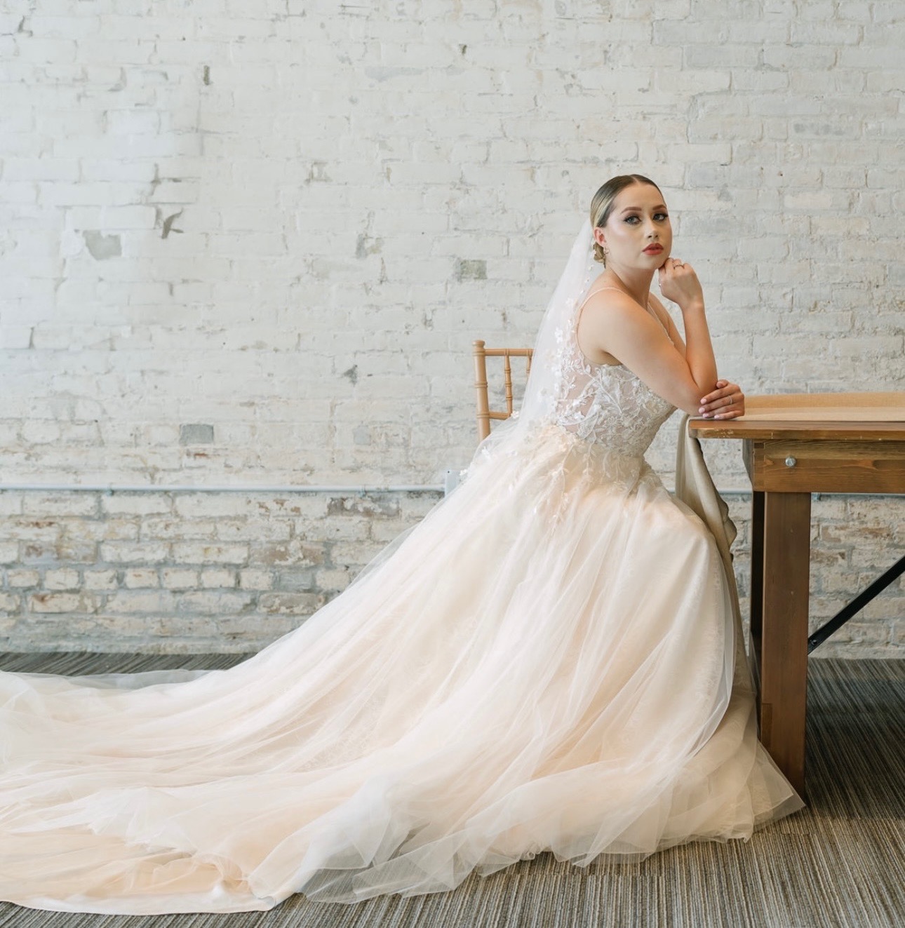 Dreamy and romantic, this soft tulle ball gown features a sheer lace bodice and an ethereal flowing train that glides wi