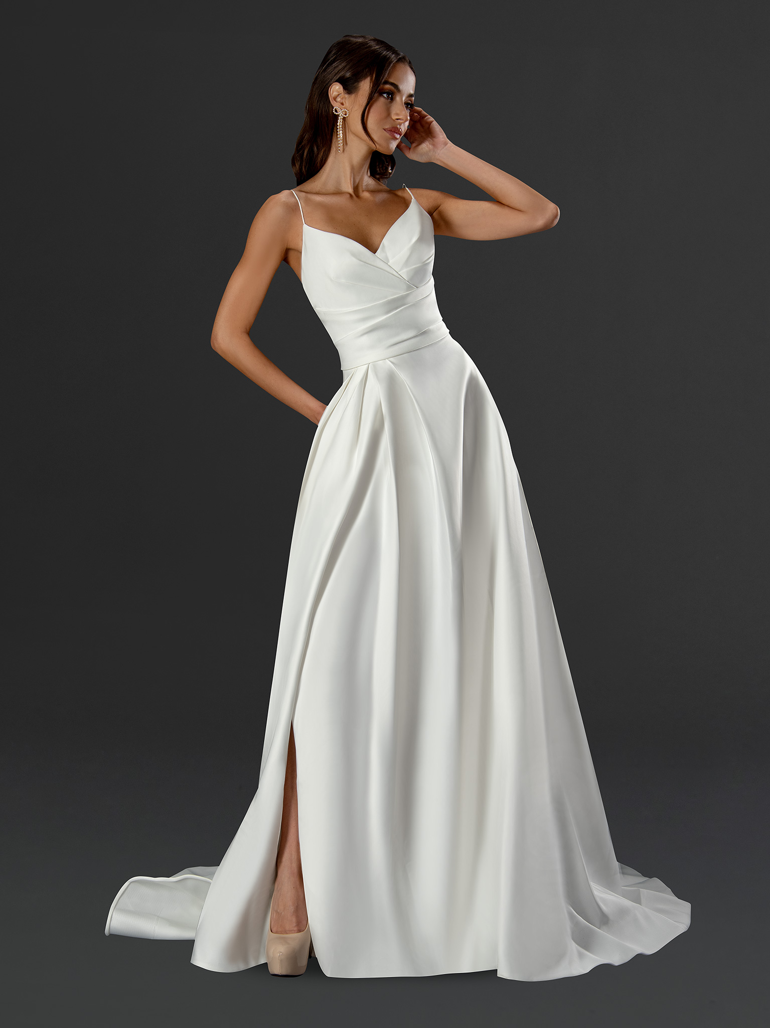 Chic, sleek, and stunning in its simplicity. This satin wedding gown features delicate spaghetti straps, a flattering ru