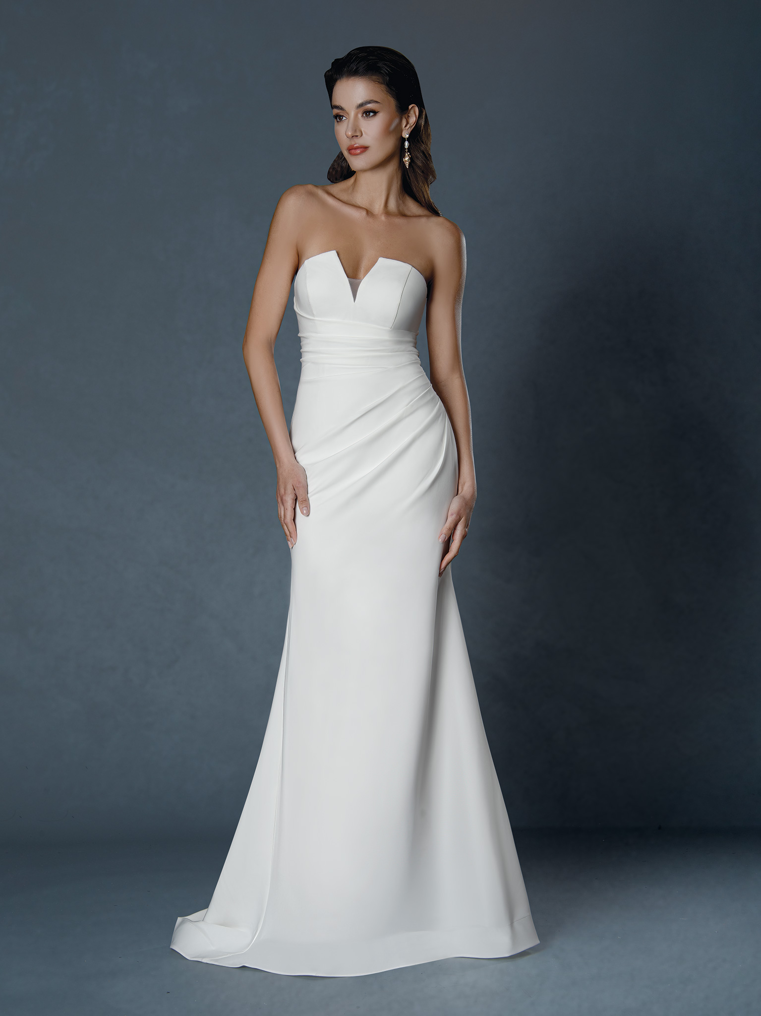 Sophisticated and effortlessly chic, this strapless satin gown features a sculpted neckline and softly draped bodice tha