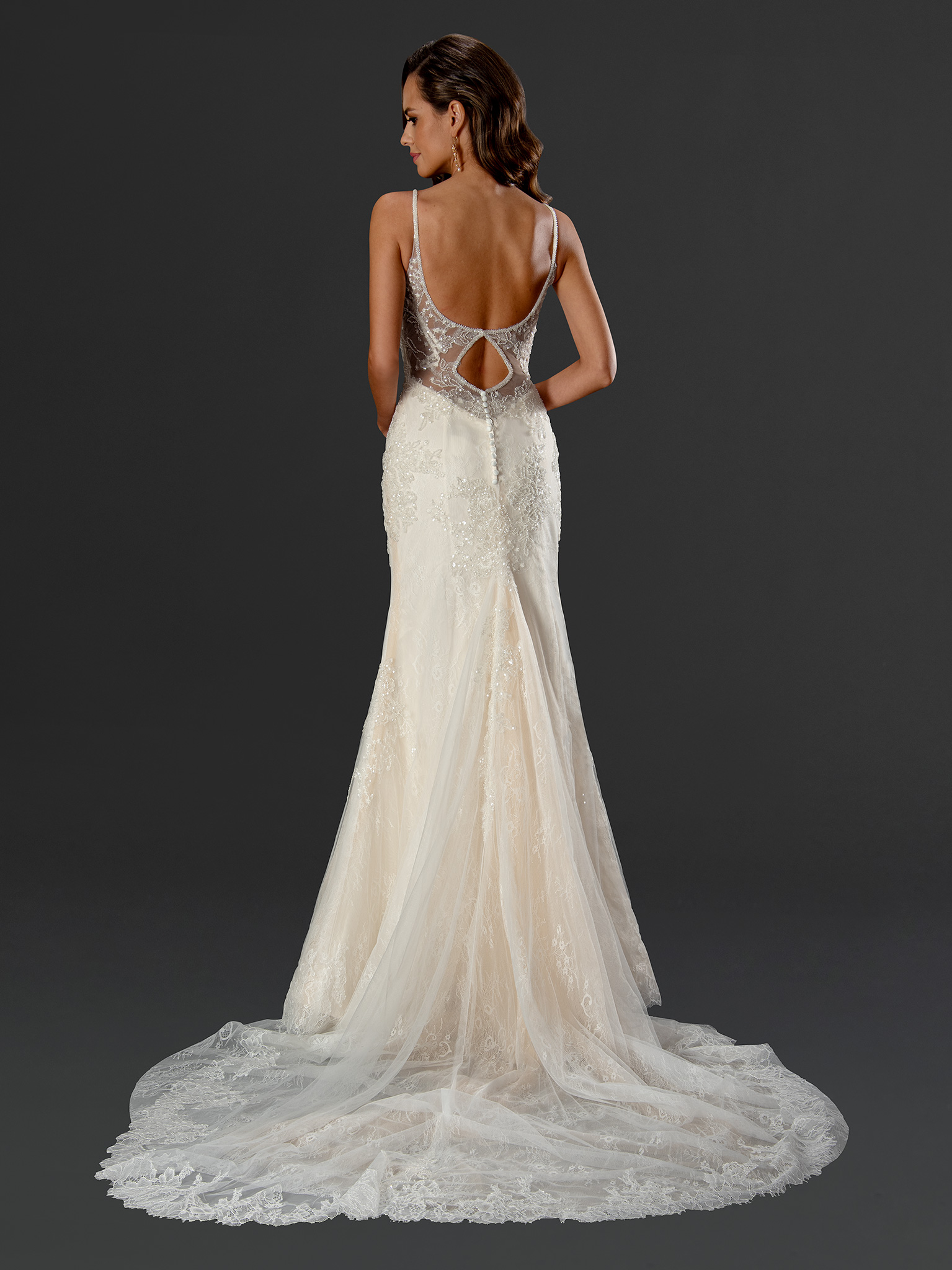 A gown designed to captivate from every angle. Featuring a beaded illusion back with a delicate keyhole cutout and a flo