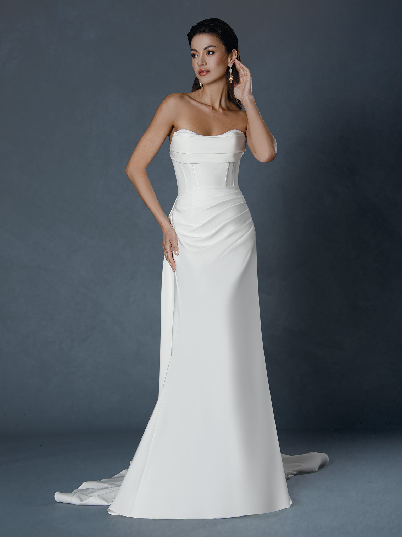 Chic simplicity meets refined luxury. This strapless satin gown features a structured corset bodice and sleek draped ski