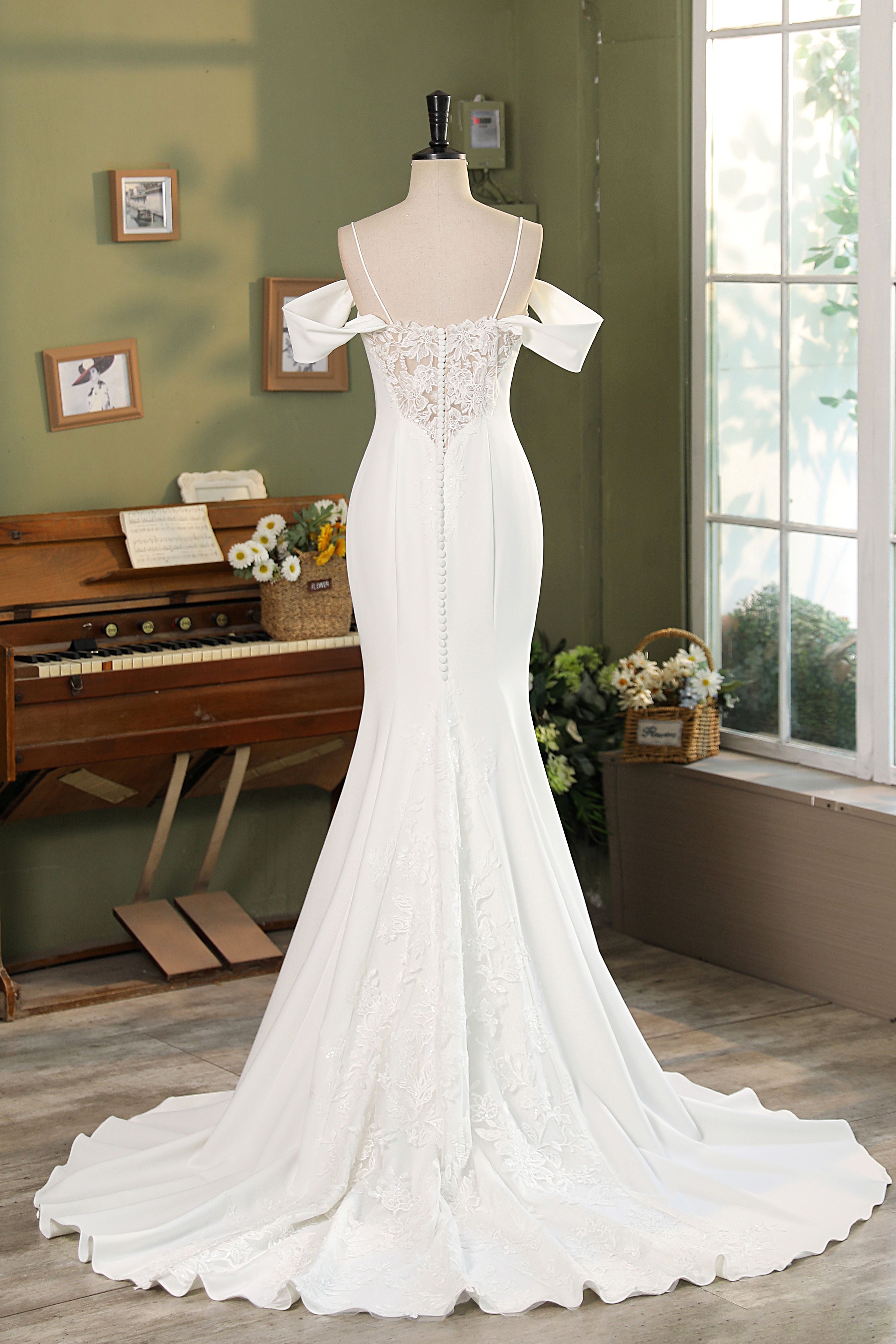 This stunning wedding gown beautifully merges the elegance of crepe and lace to create a captivating silhouette. The fit