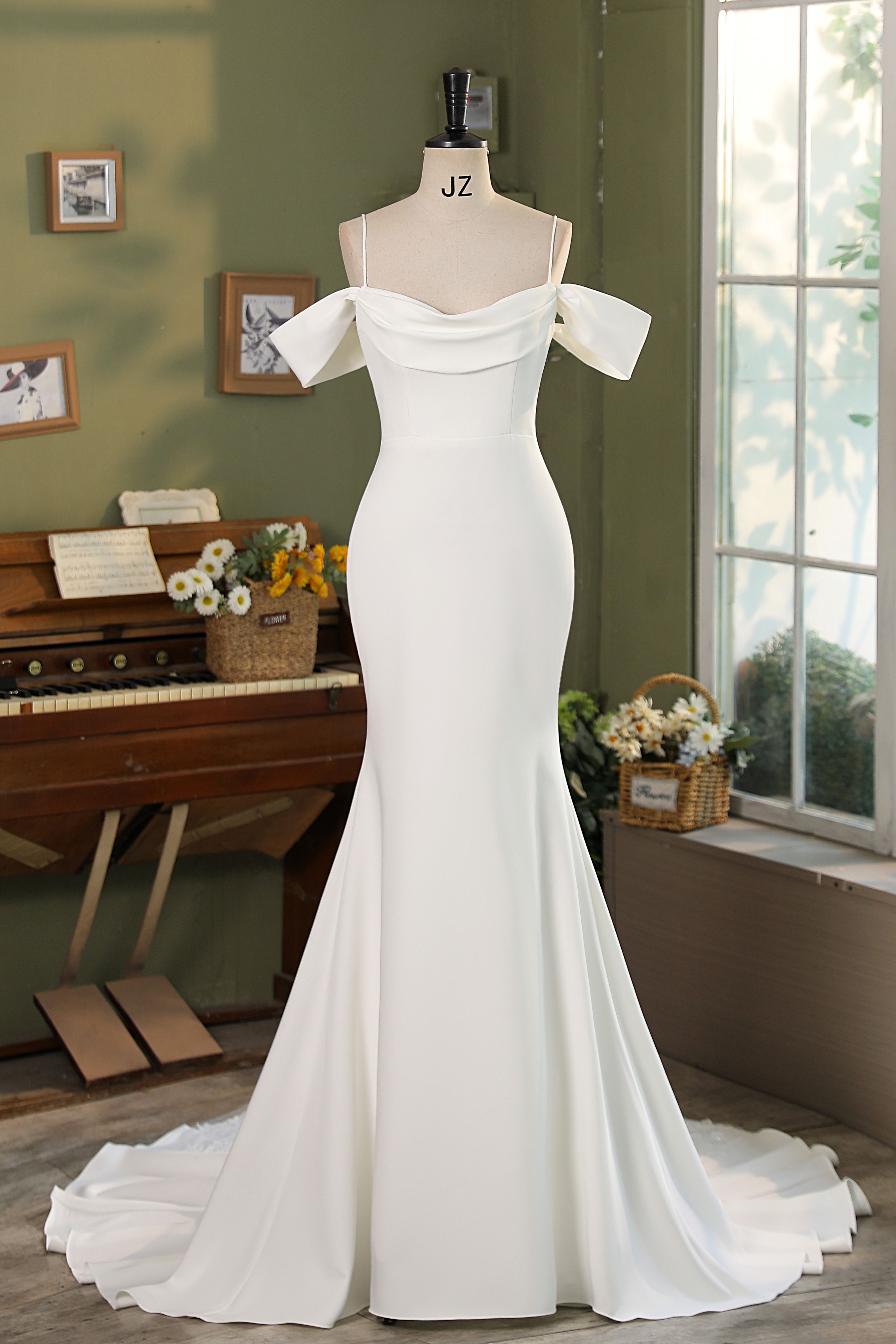 Chic and timeless, this crepe gown features a romantic off-shoulder neckline with delicate draping and a sculpted silhou