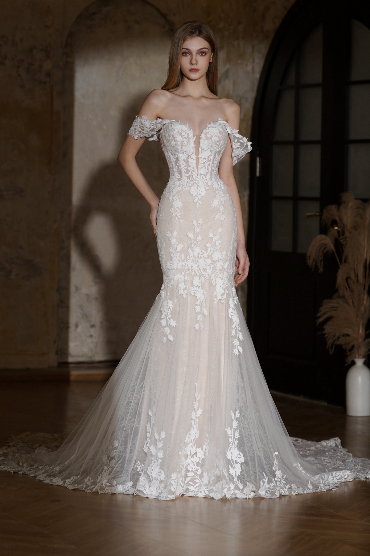 Feminine, fitted, and unforgettable — this lace fit and flare wedding gown features a sculpted corset bodice, off-should