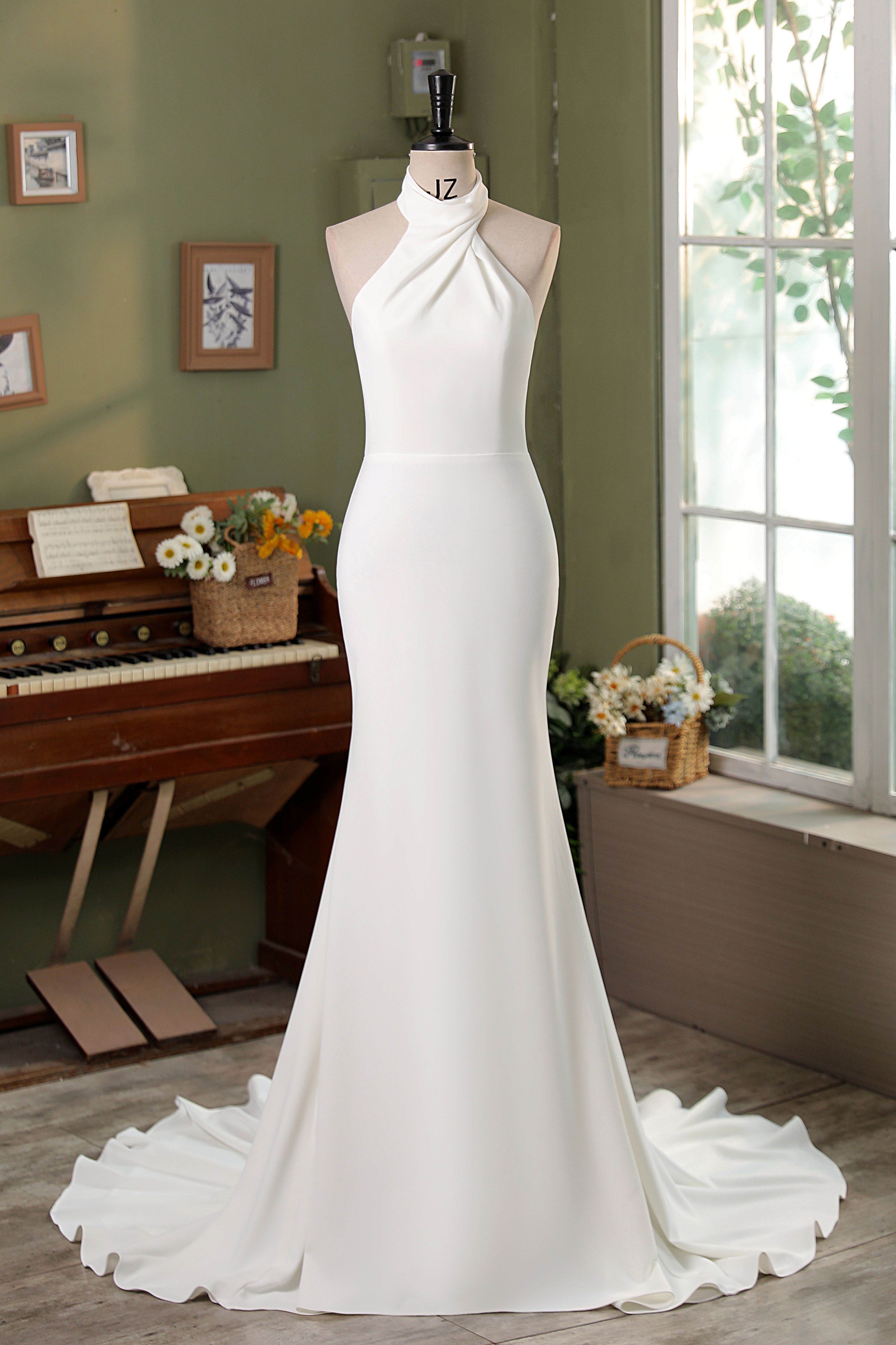 Clean, modern, and effortlessly elegant — this crepe wedding gown features a high halter neckline and a beautifully scul