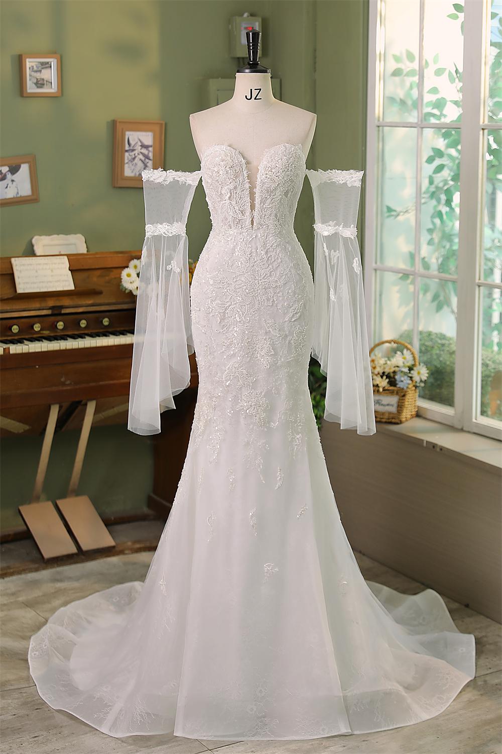 Bold yet timeless — this off-shoulder mermaid wedding gown features detachable sheer tulle sleeves, intricate lace detai