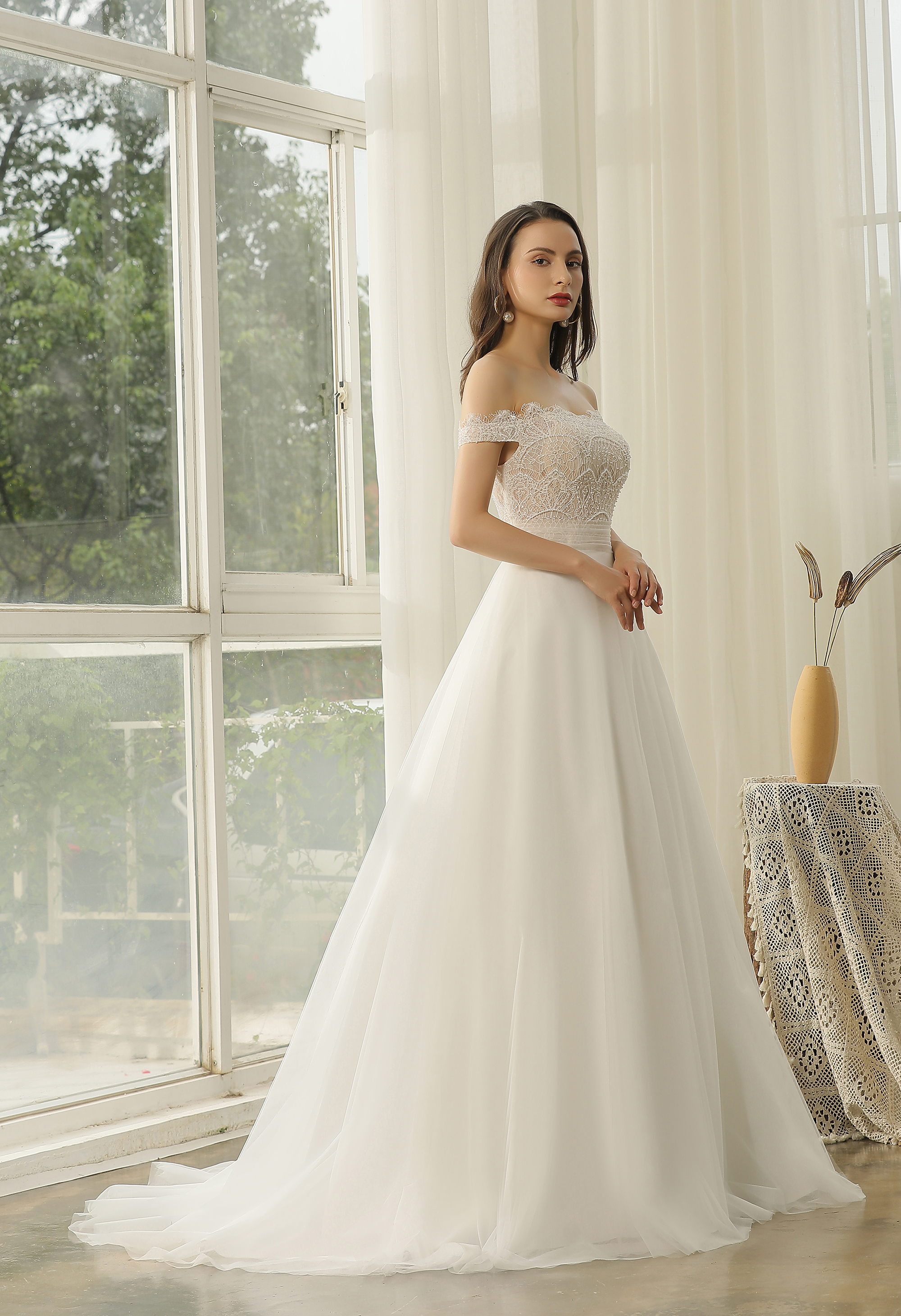 Off-the-shoulder lace and a flowing tulle skirt create timeless romance. Designed for San Antonio brides who love effort