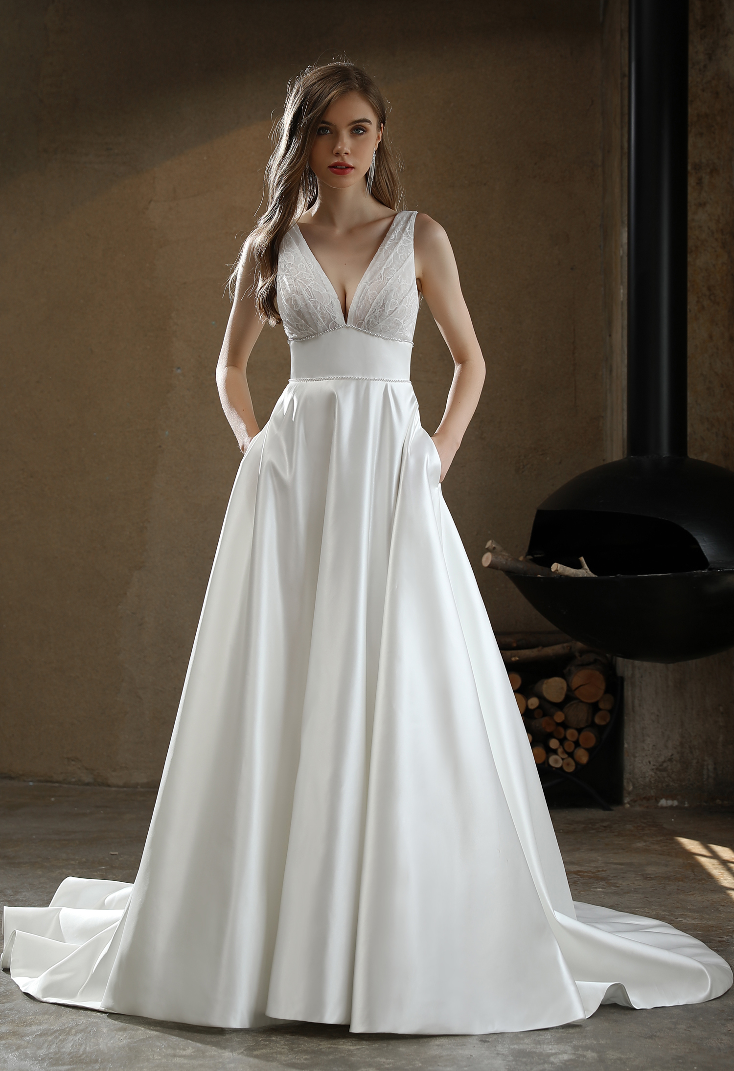 A satin A-line gown with lace bodice and deep V neckline balances simplicity and charm—made for elegant, modern brides. 