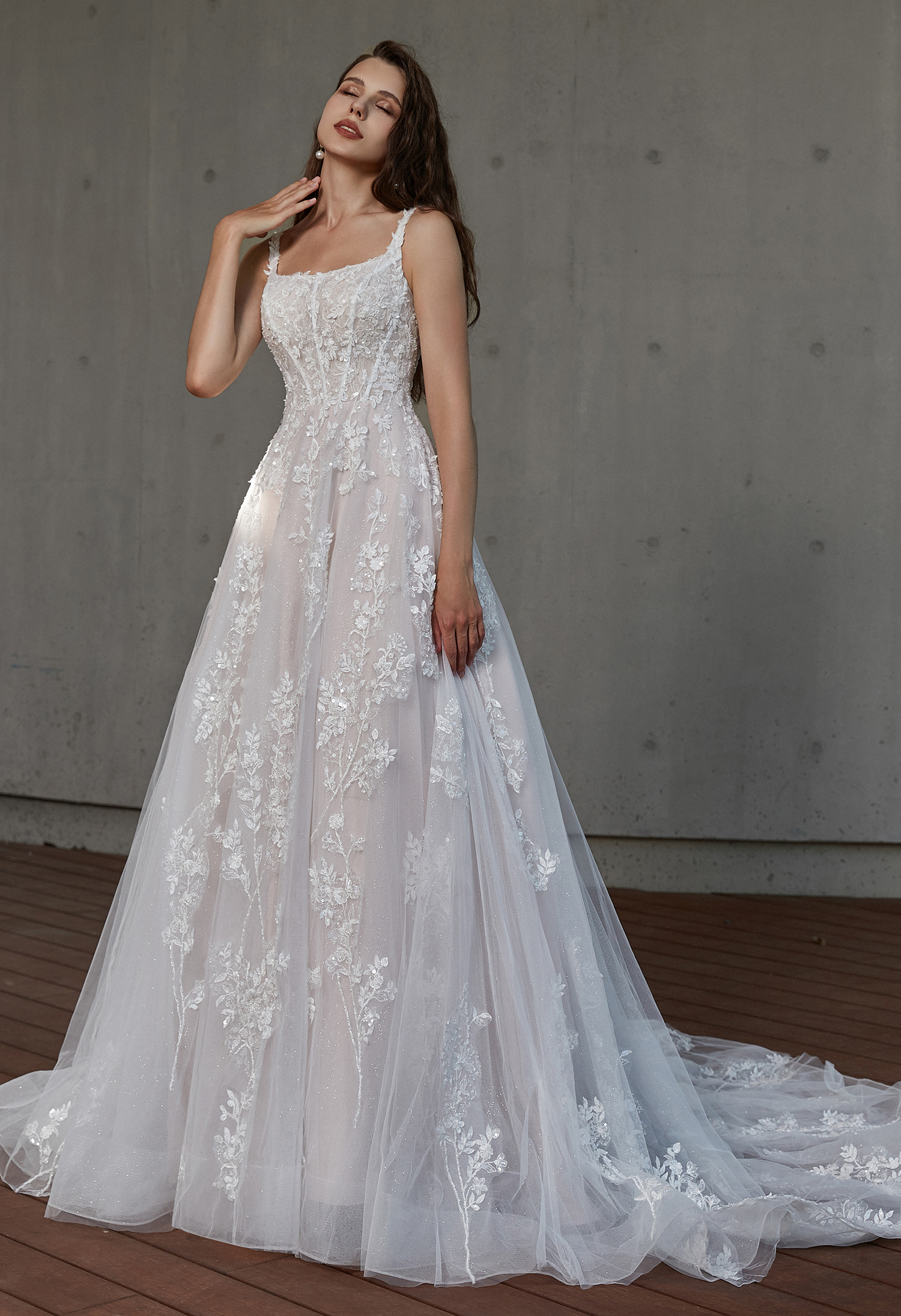 A delicate floral lace A-line gown with a soft corset bodice and subtle sparkle. The romantic details and flowing train 