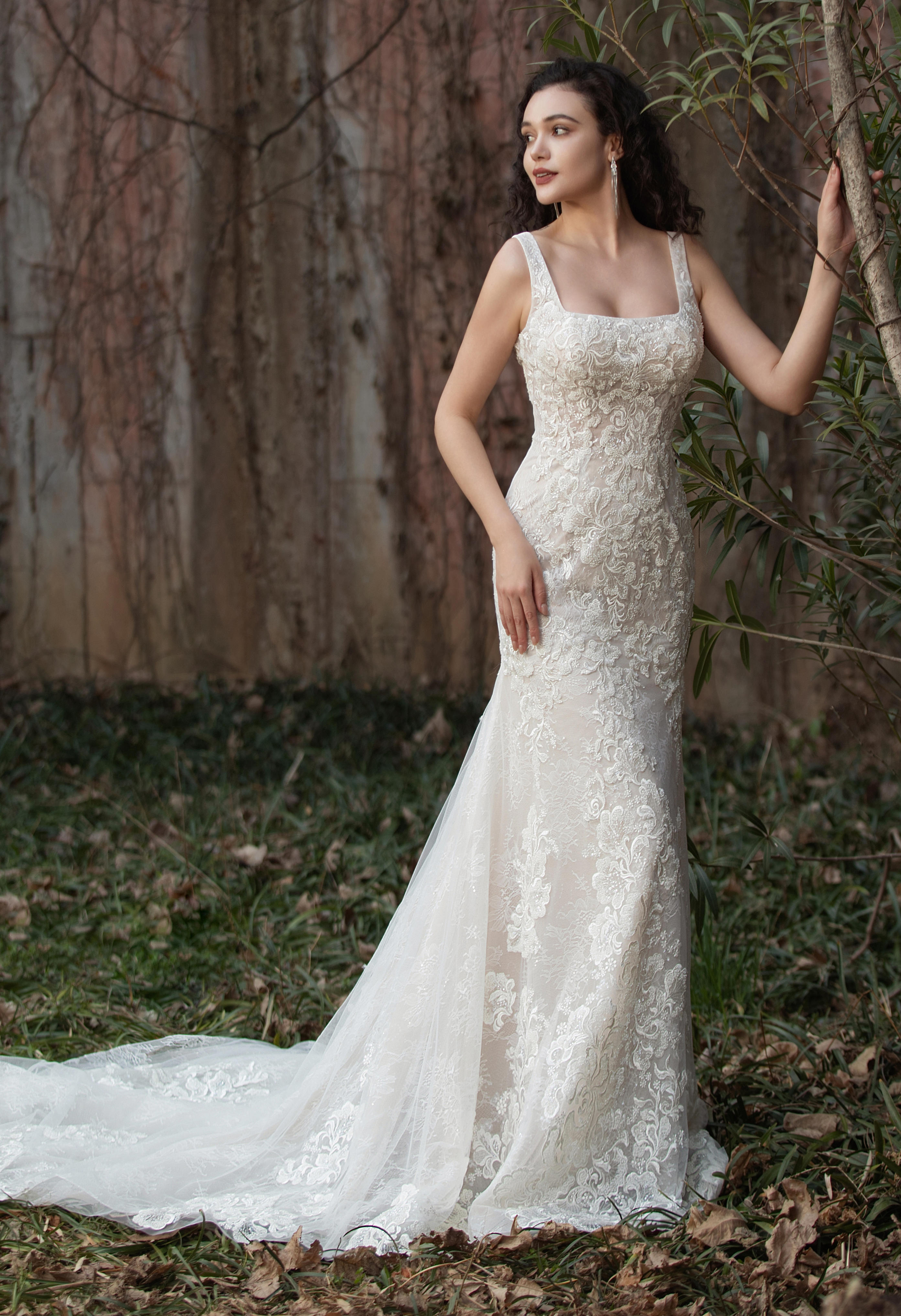 This square-neck lace gown exudes timeless romance with intricate detailing and a graceful train. Perfect for brides see