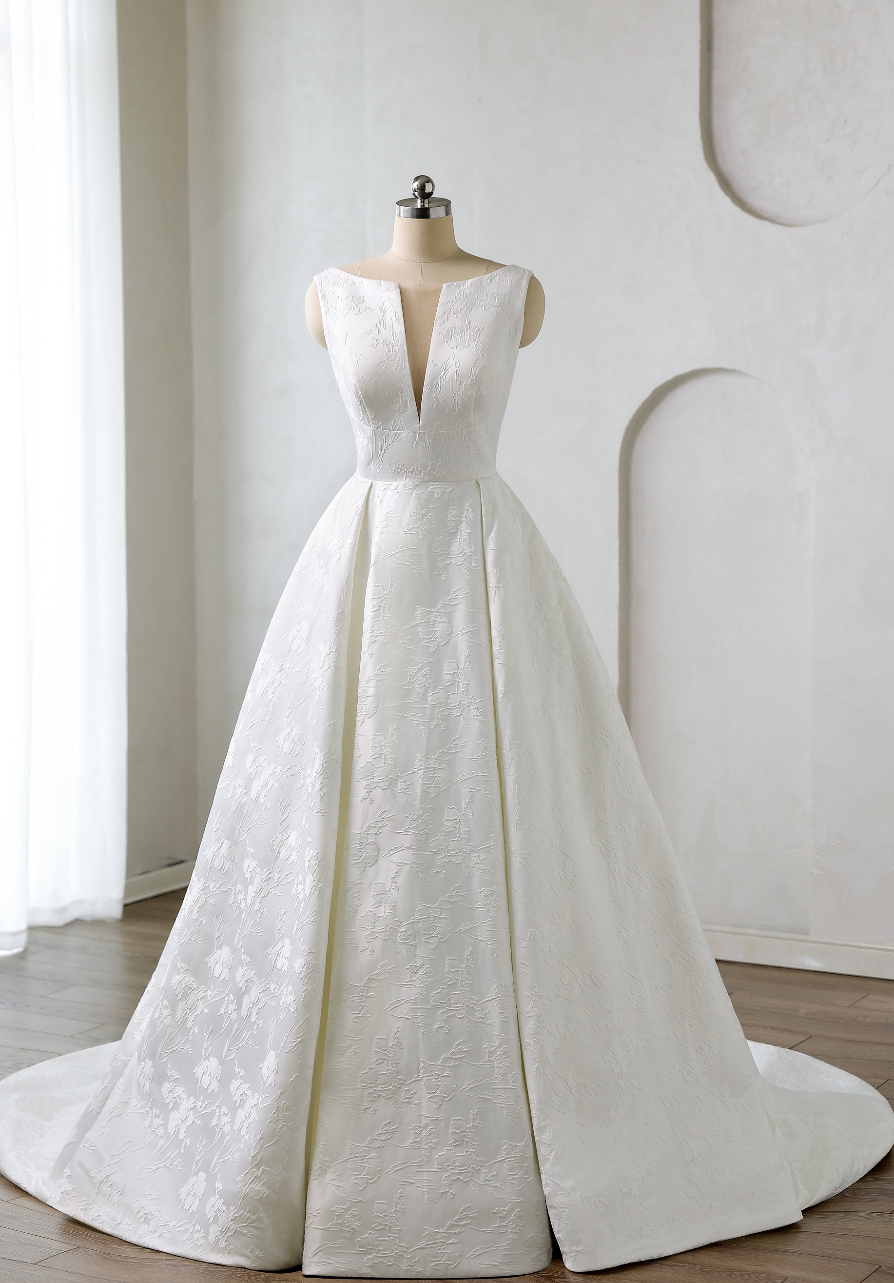 Elegant jacquard fabric and a plunging neckline blend texture and modern luxury. A perfect choice for brides who love re