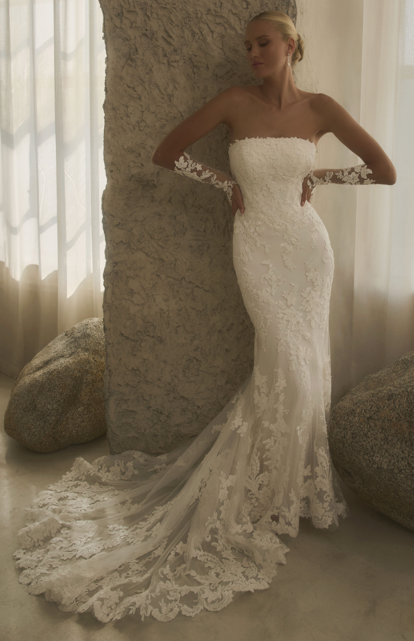 Effortlessly romantic, this strapless lace fit-and-flare gown features delicate floral appliqués and optional matching s