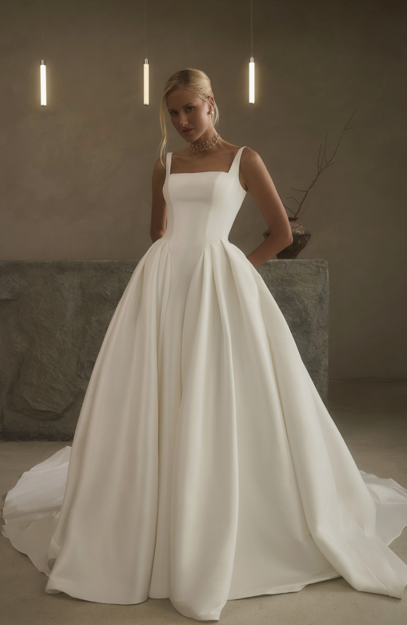 square neckline, sleek seams, and voluminous pleated skirt. Perfect for the bride who loves timeless elegance with a mod