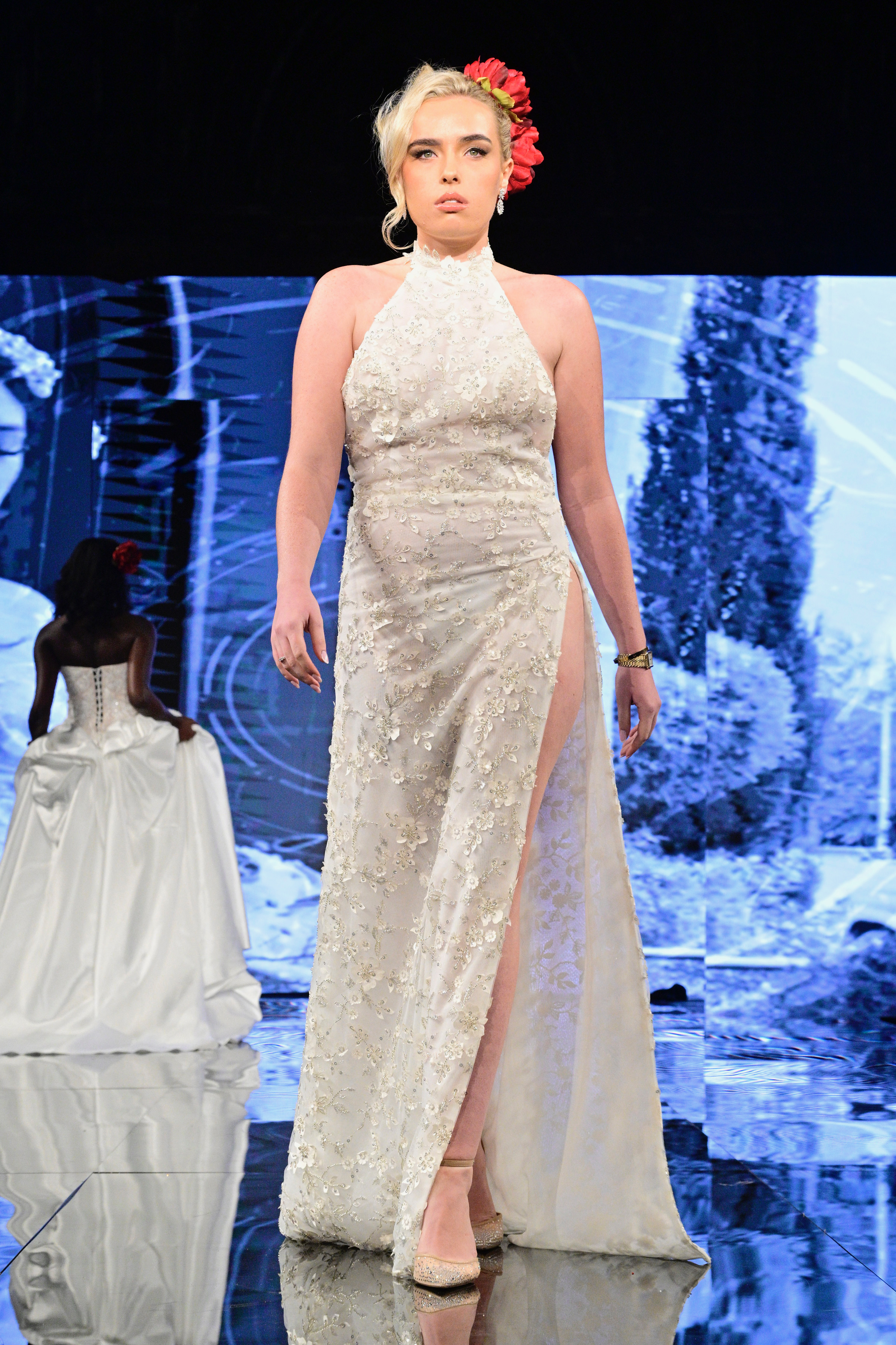 Fierce meets feminine in this modern halter gown adorned with intricate beaded floral appliqué and a daring thigh-high s