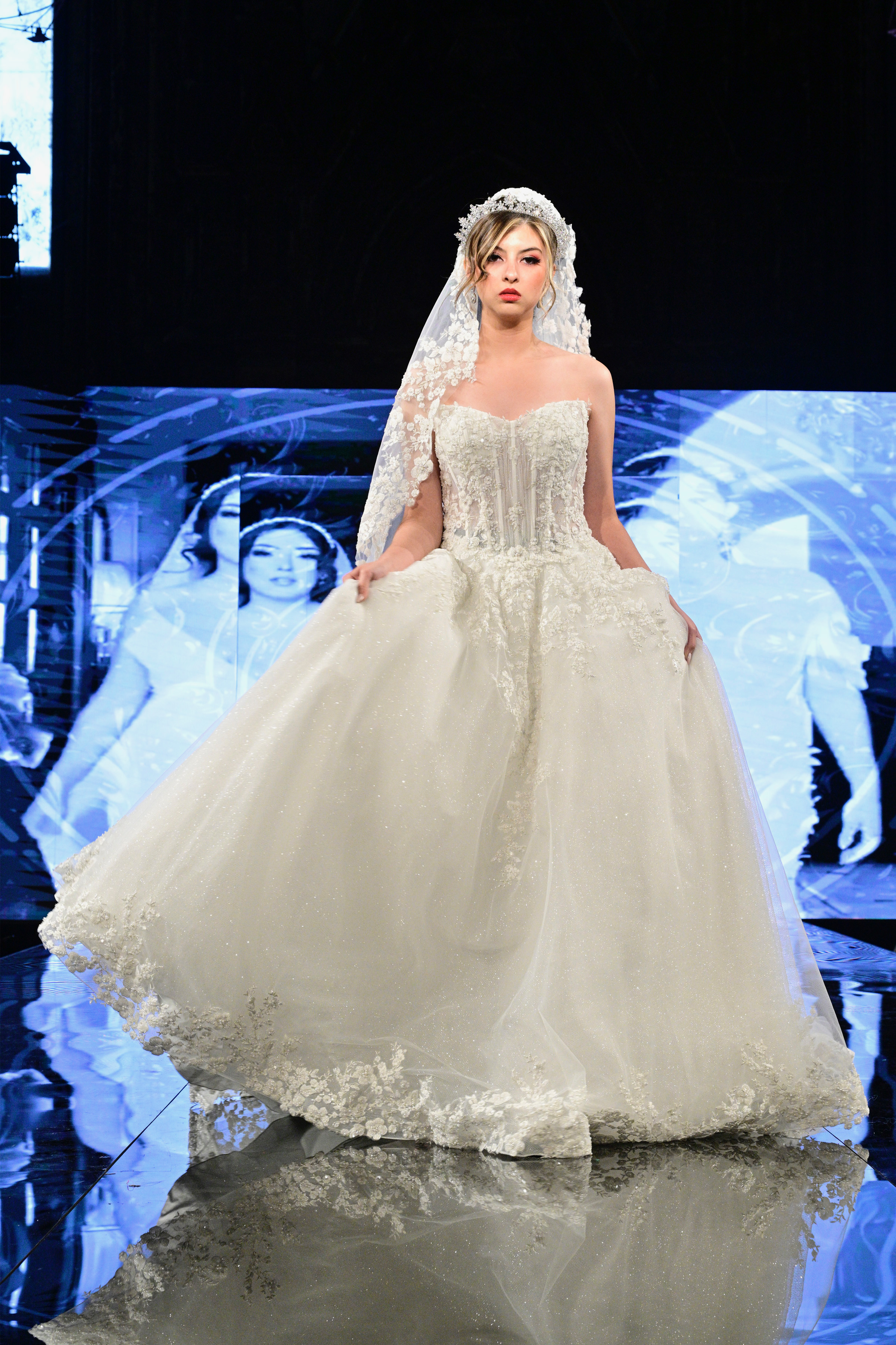 A breathtaking fusion of romance and drama, this ball gown features a structured corset bodice with intricate lace embro