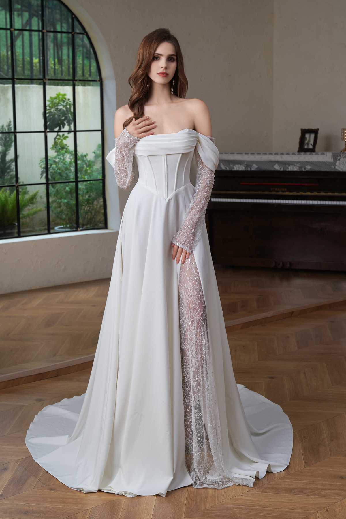 A breathtaking blend of structure and softness, this off-the-shoulder gown features a corset bodice, detachable lace sle