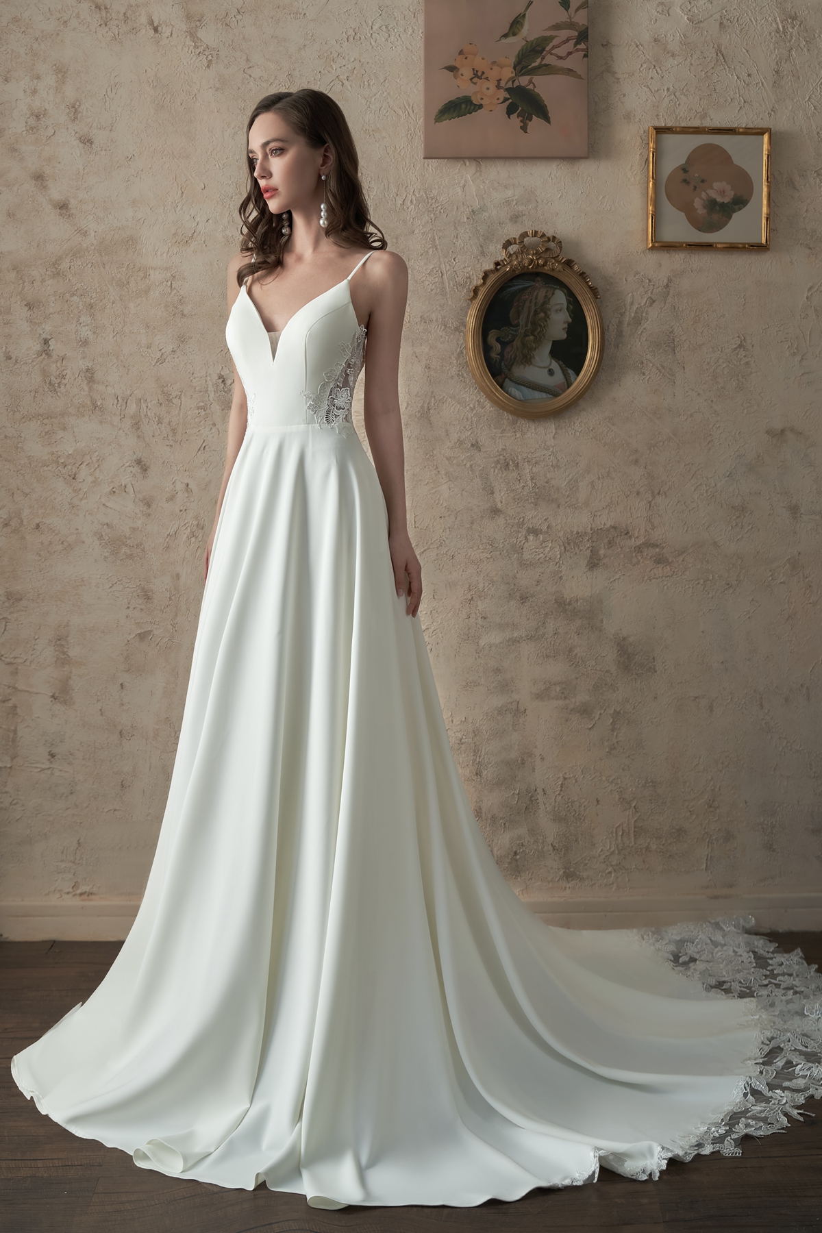 Timeless and breathtaking, this satin ball gown features a delicate lace bodice, flowing skirt, and cathedral-length tra