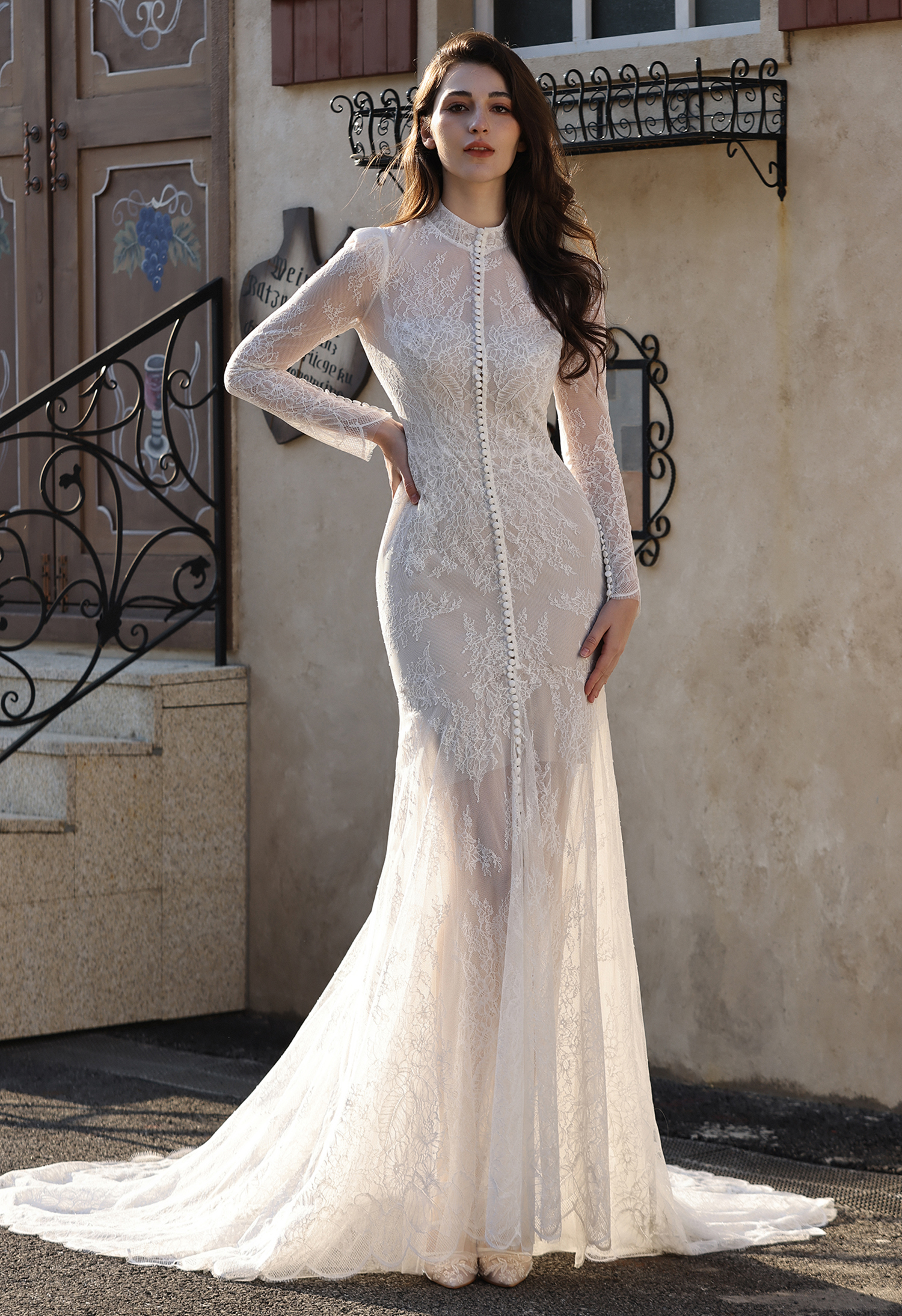 This unique lace wedding dress features a sleek, sculpted silhouette paired with a detachable sheer lace jacket for a st