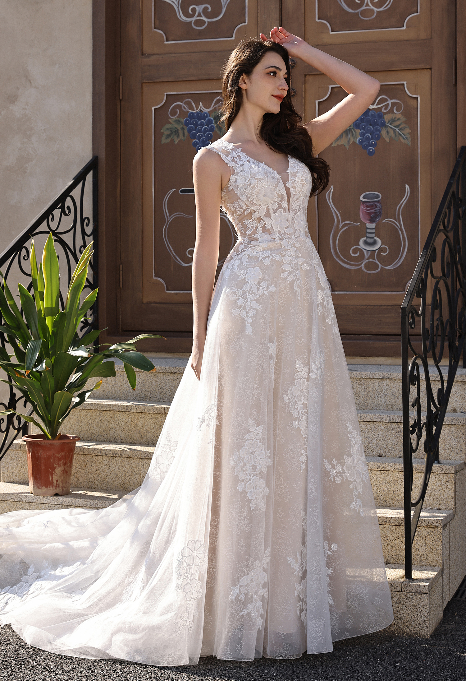 This lace A-line wedding dress features a romantic floral lace bodice, a soft flowing skirt, and a dramatic open back ac