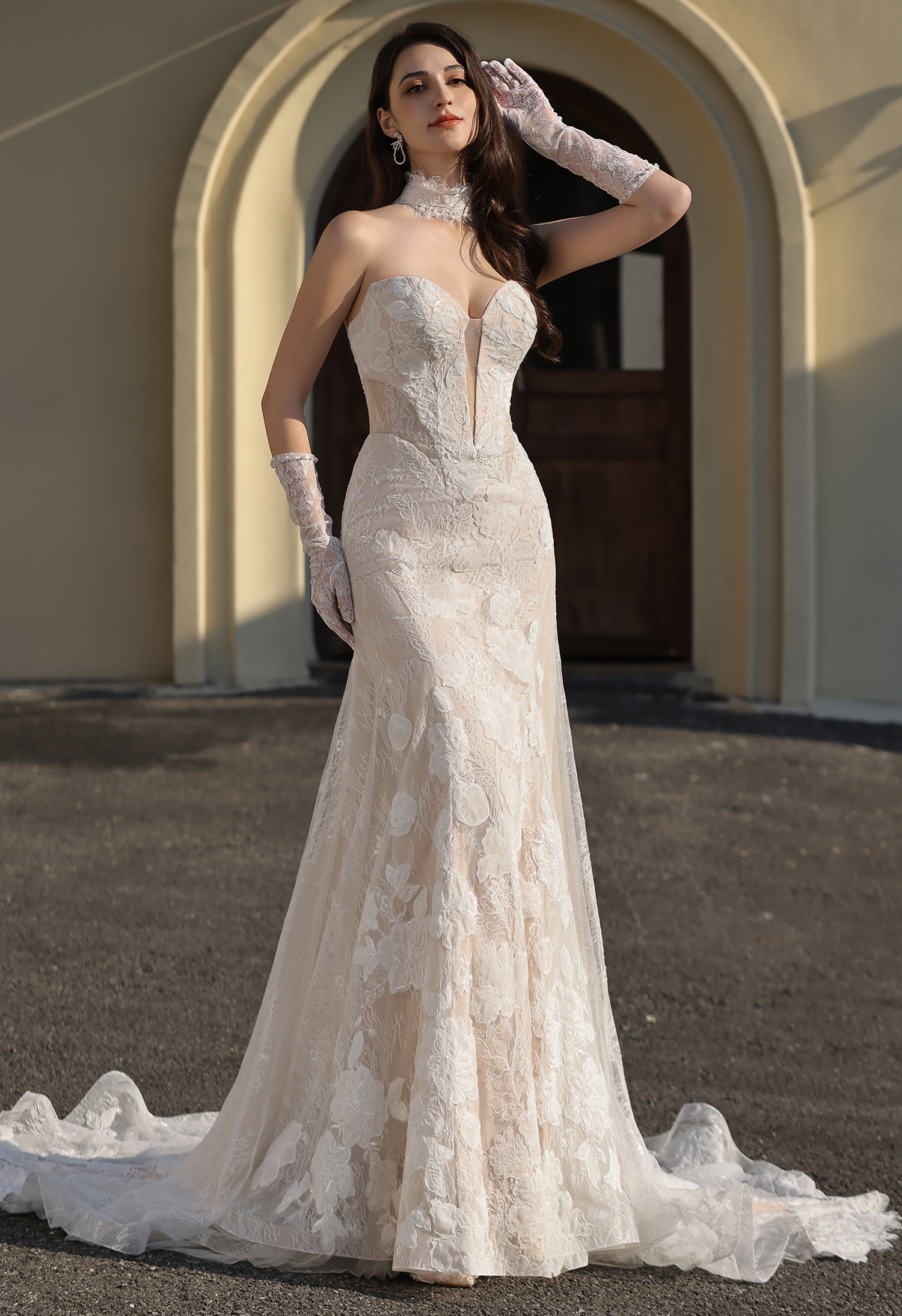 This strapless lace wedding dress features a sculpted corset bodice with intricate floral lace, paired with a matching l